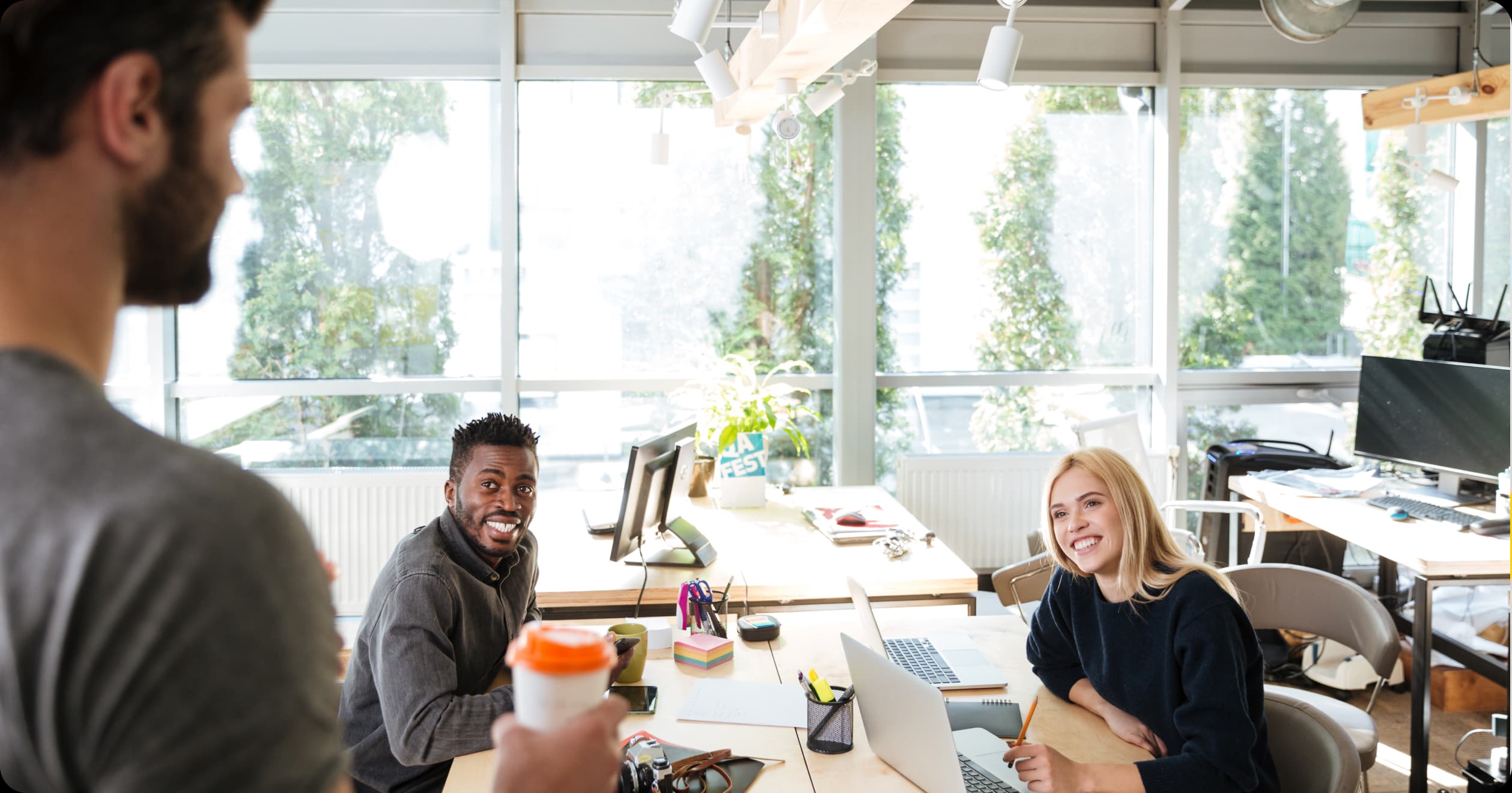 Happy coworkers in a bright office promoting self-care and well-being.