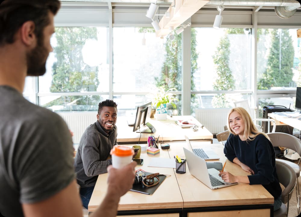 Happy coworkers in a bright office promoting self-care and well-being.