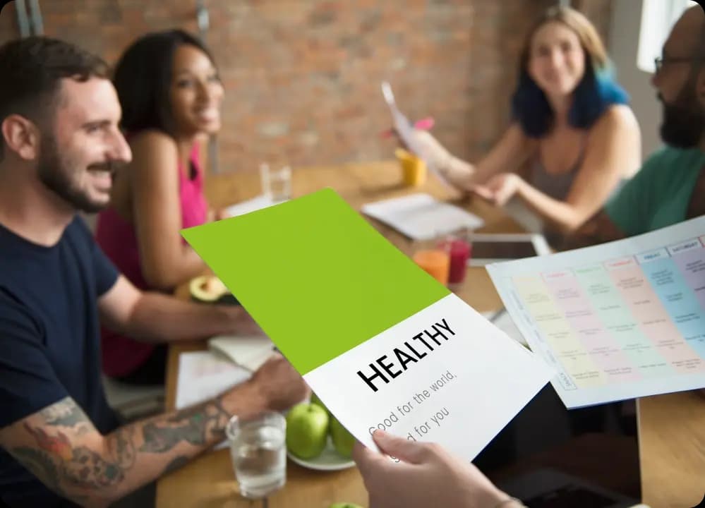 Team discussing healthy lifestyle materials during a corporate wellness planning session