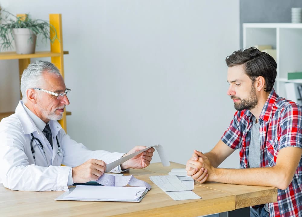Physician discussing health results with male patient during wellness checkup