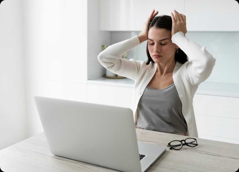 Stressed woman at desk highlighting workplace neurological health risks.