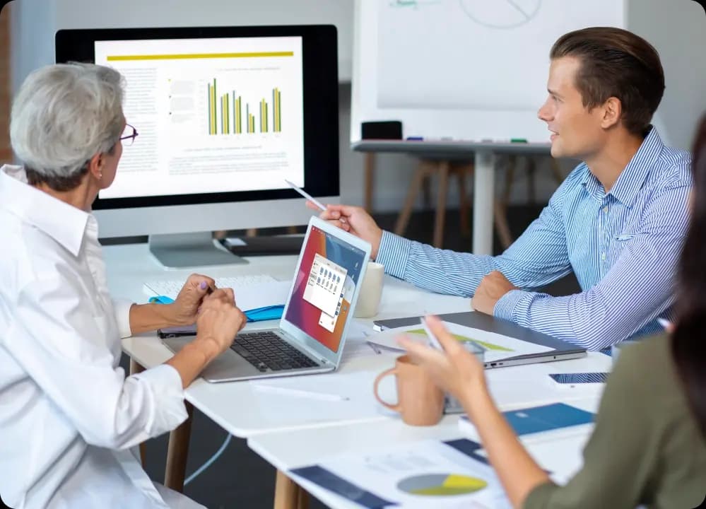Colleagues analyzing wellness program metrics on screen to evaluate ROI and outcomes