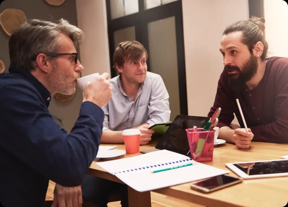 Group of male employees in a serious discussion about long-term wellness program strategies