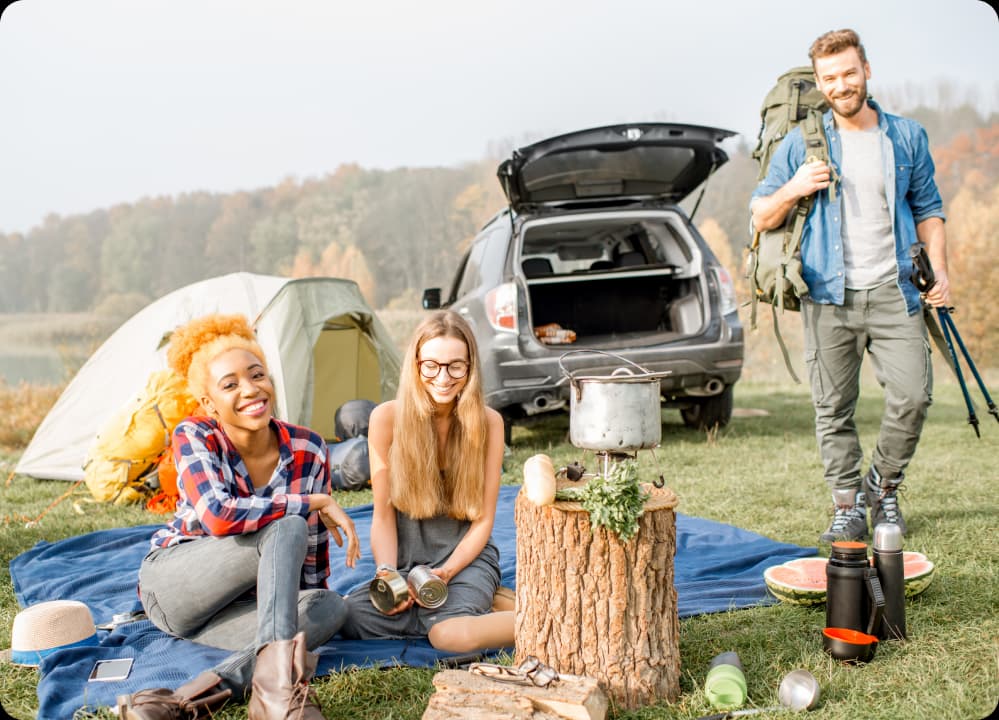 Colleagues camping outdoors with healthy food, showing smart travel and wellness for busy professionals.