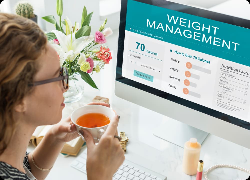 Woman reviewing a weight management dashboard showing calorie information and exercise equivalents—representing chronic disease in the workplace.