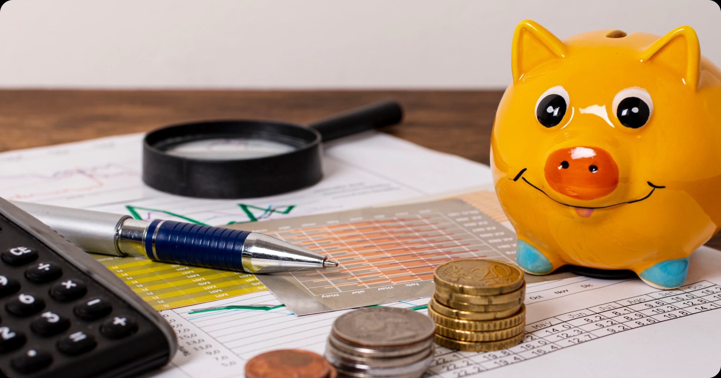 Financial planning tools with piggy bank, charts, coins, and calculator on desk