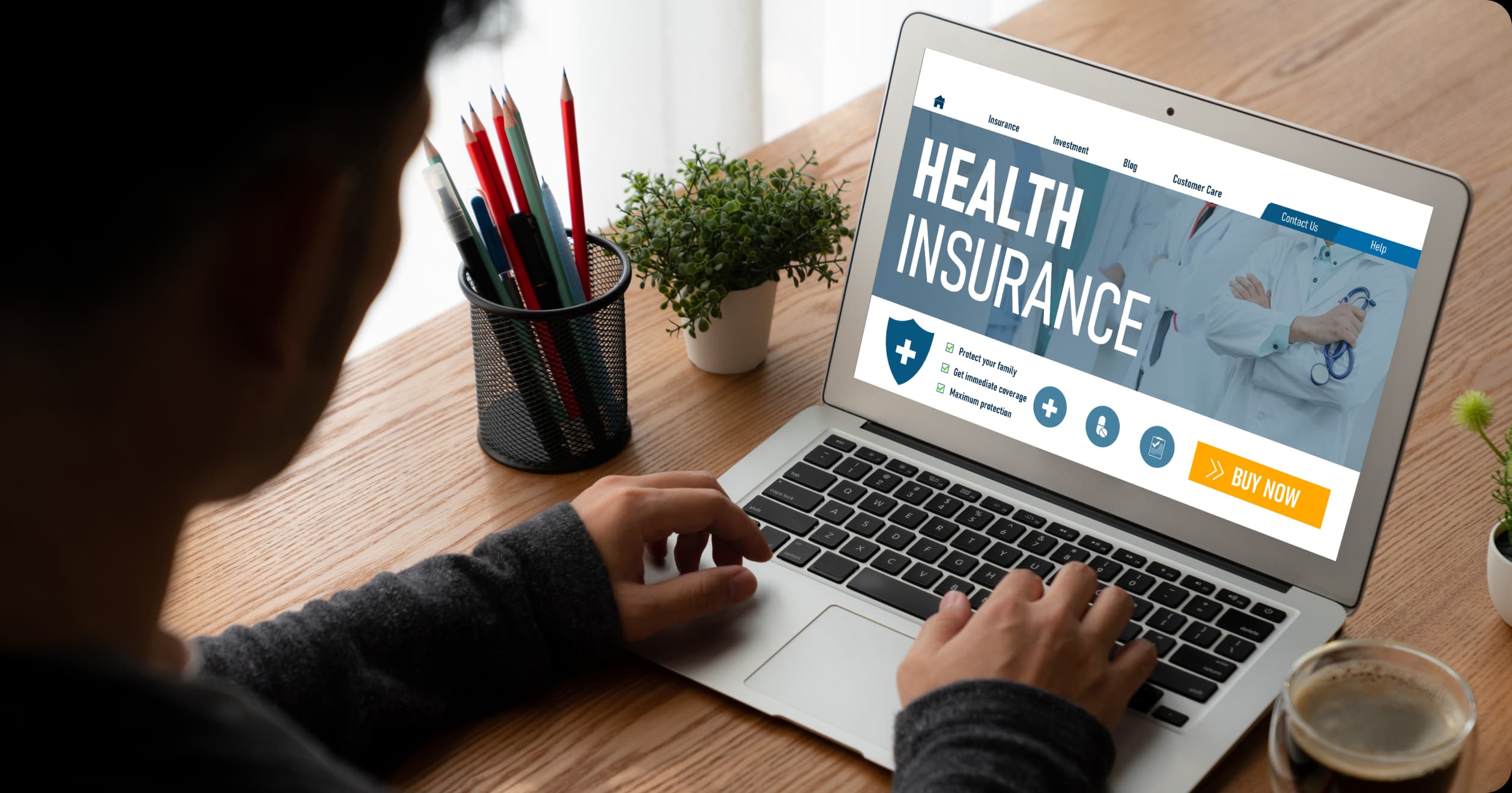 Man using laptop to explore health insurance options, highlighting digital wellness trends