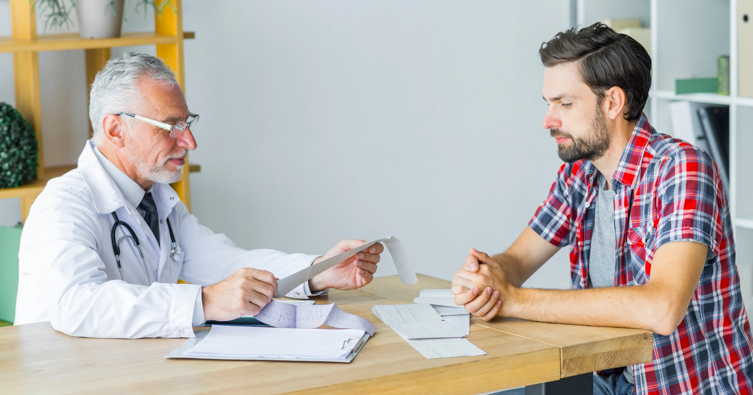 Physician discussing health results with male patient during wellness checkup