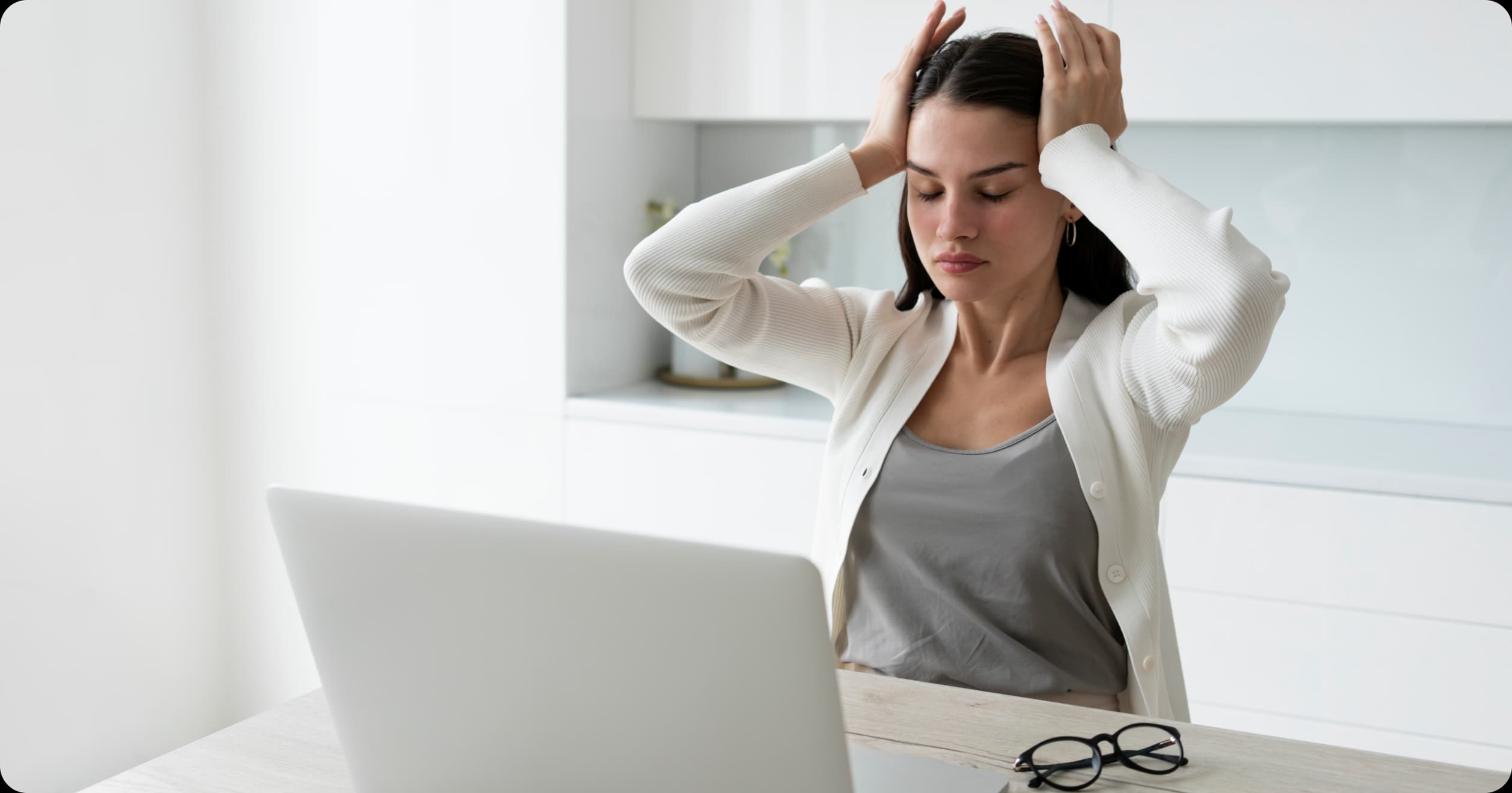 Stressed woman at desk highlighting workplace neurological health risks.