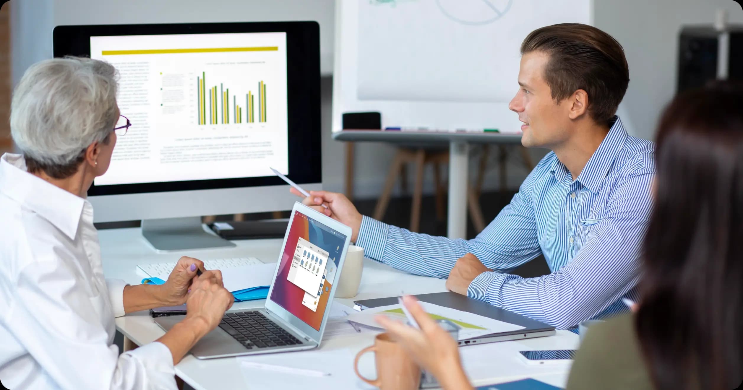 Colleagues analyzing wellness program metrics on screen to evaluate ROI and outcomes