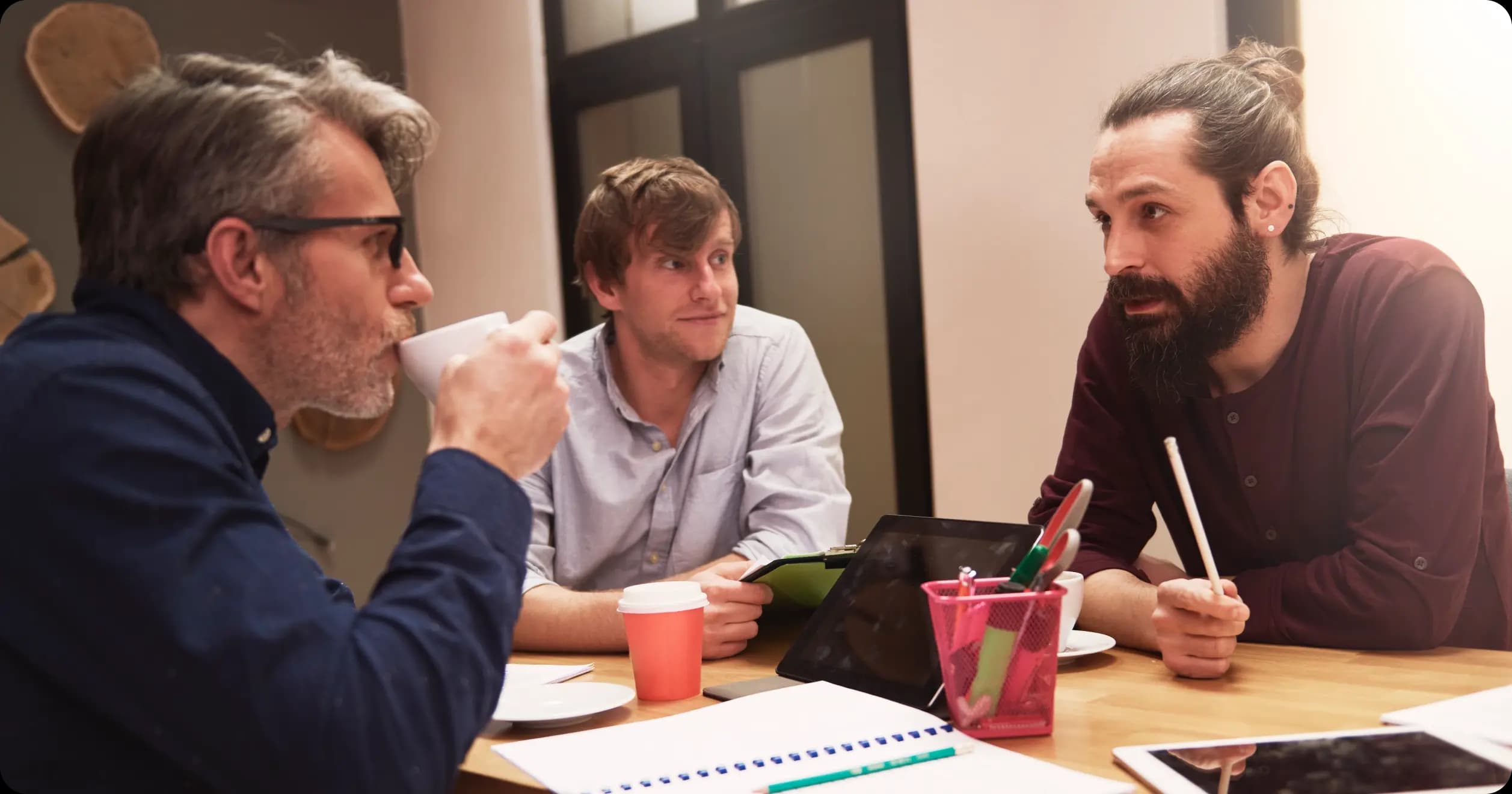 Group of male employees in a serious discussion about long-term wellness program strategies