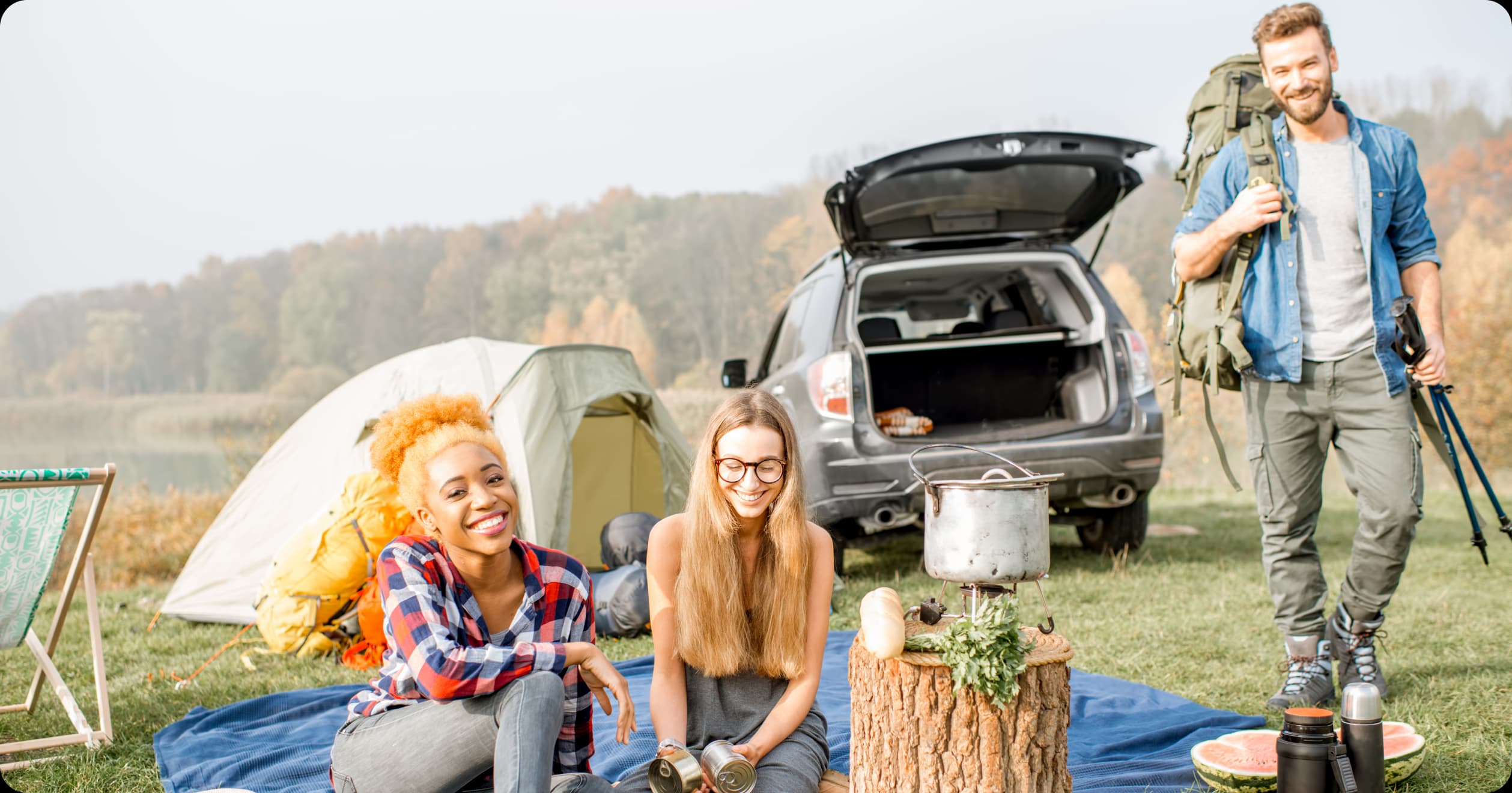 Colleagues camping outdoors with healthy food, showing smart travel and wellness for busy professionals.